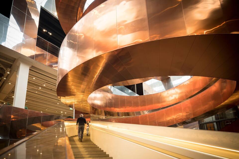 Una estructura arquitectónica moderna con elementos metálicos curvos y una escalera.