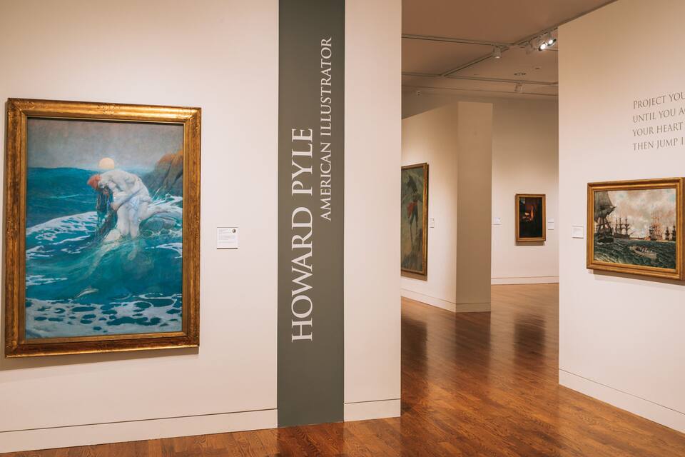 Eine Kunstgalerie mit einem Gemälde, das einen Mann im Meer in Blau zeigt.
