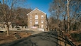 A stone building with a sign reading "Hagley Museum" in front of a forested area.