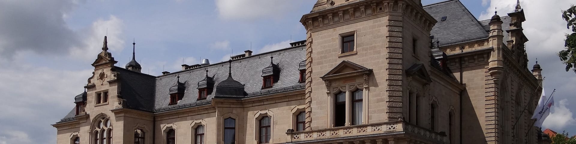 A historic building with a prominent tower and intricate architectural details.