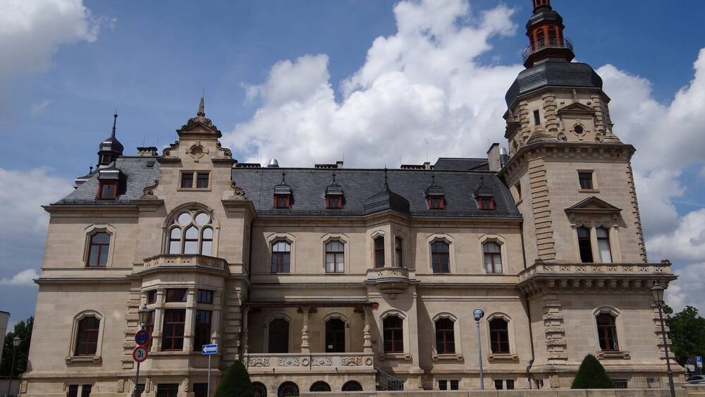 Ein großes, historisches Gebäude mit einem markanten Turm und Rundbogenfenstern.
