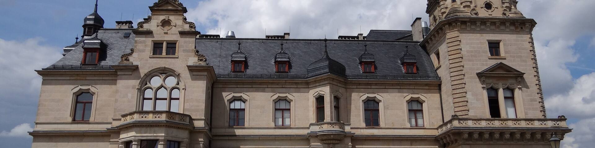 A large, historic building with a prominent tower and arched windows.