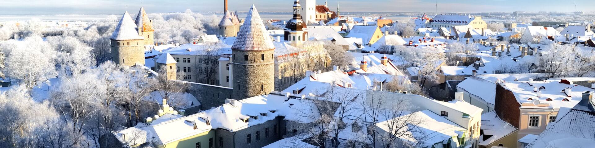 Panoramic aerial view of the old town of Tallinn, Estonia. St. Olaf's Church, fortress towers, snow-covered roofs and spires. Winter, Christmas vacations, travel destinations, sightseeing, culture