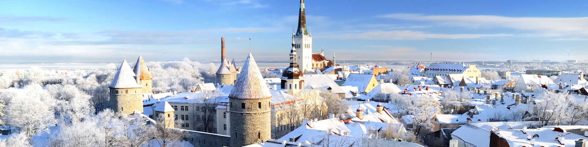 Panoramic aerial view of the old town of Tallinn, Estonia. St. Olaf's Church, fortress towers, snow-covered roofs and spires. Winter, Christmas vacations, travel destinations, sightseeing, culture
