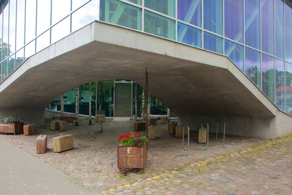 A modern building with a unique concrete arch structure.