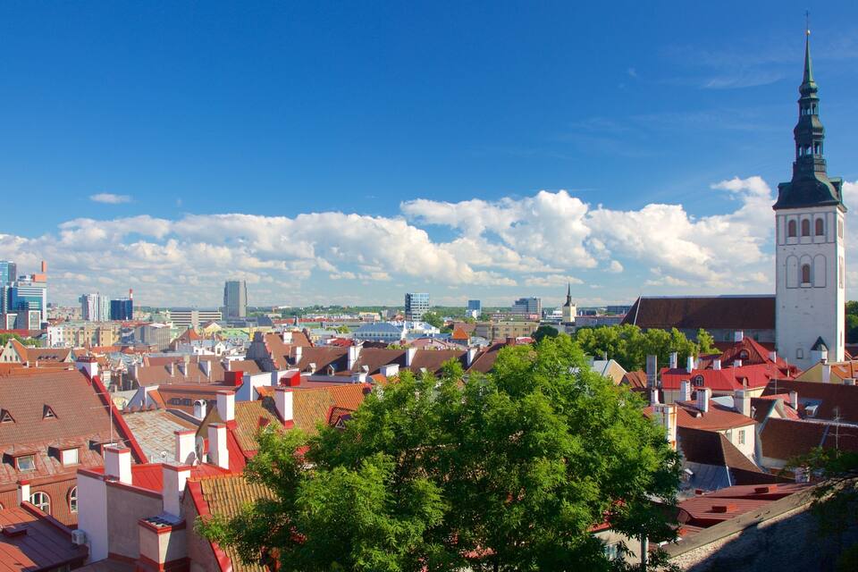 A cityscape with red-roofed buildings, a prominent church tower, and modern skyscrapers in the background.