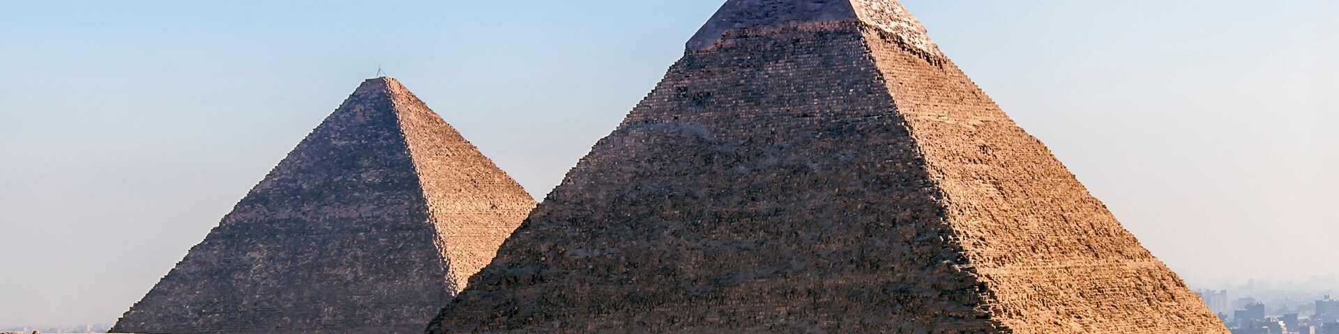 Dos pirámides enormes en un paisaje desértico bajo un cielo despejado.