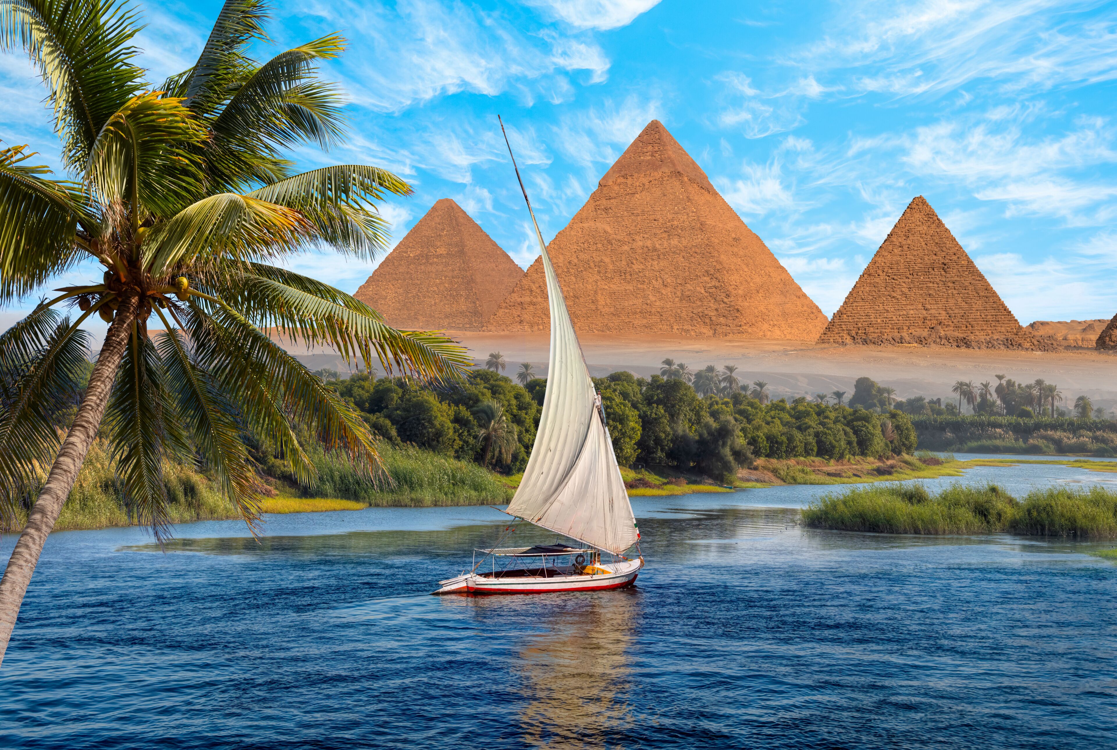 Beautiful Nile scenery with traditional Felluca sailing boat in the Nile on the way to Giza pyramids and The great Sphinx  - Cairo, Egypt  