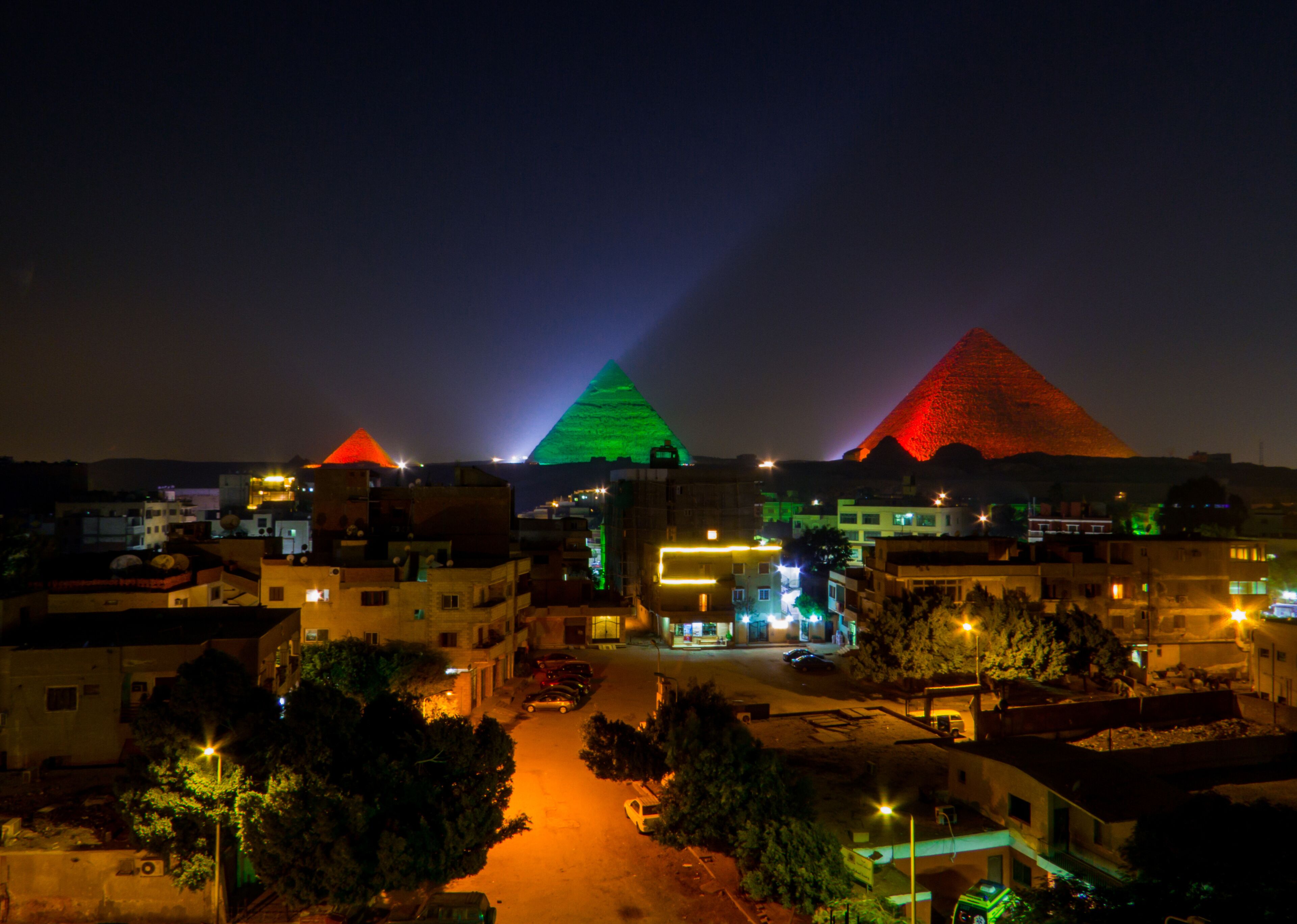 View of the Pyramids of Giza illuminated at night. In Cairo, Egypt