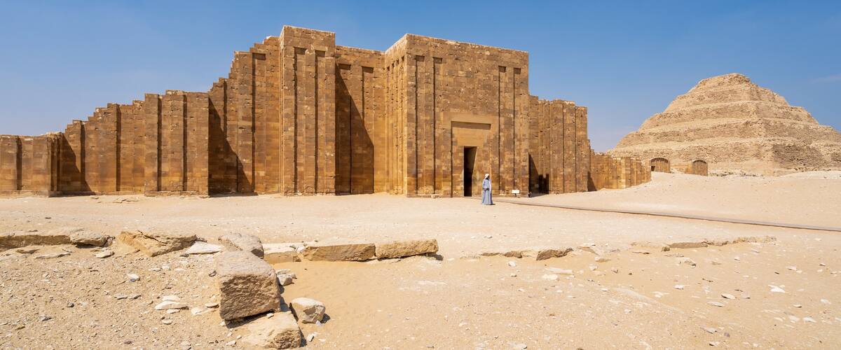 A large ancient Egyptian temple complex with a pyramid in the background.