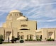 A large, beige building with a dome and arched windows.
