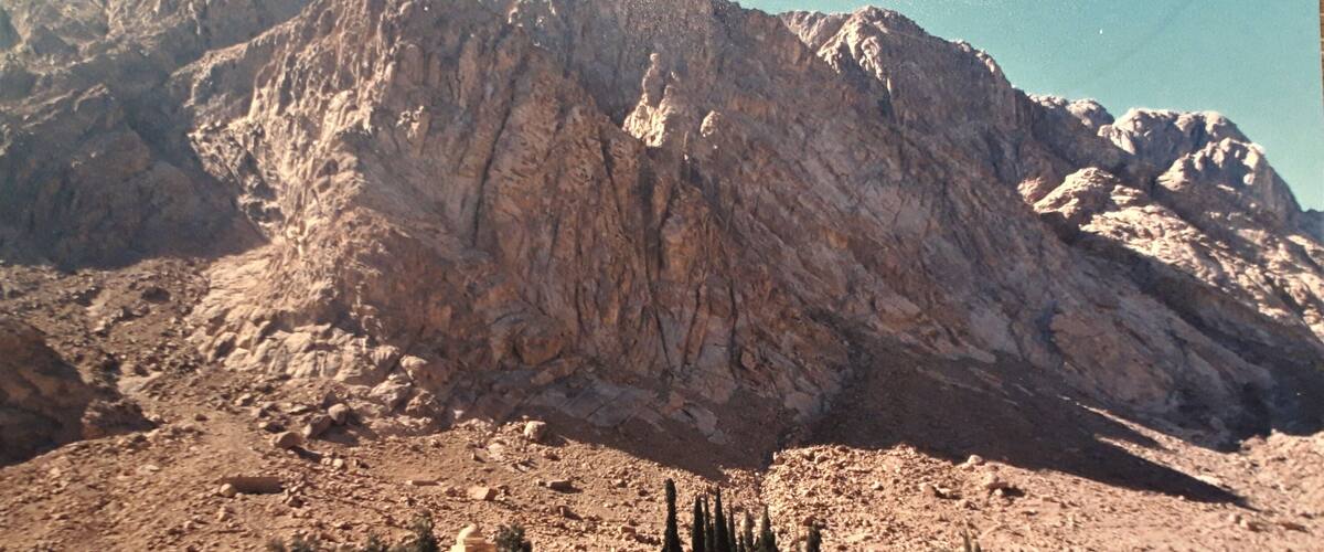 A model of a desert landscape with a model of a fortress and mountains in the background.