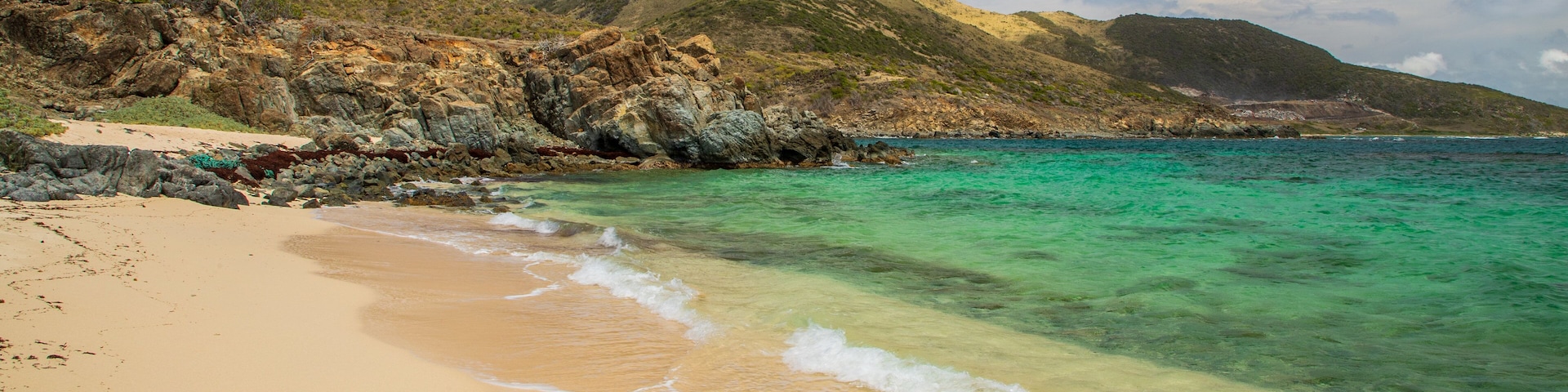 Pinel Island featuring general coastal views, a sandy beach and rugged coastline