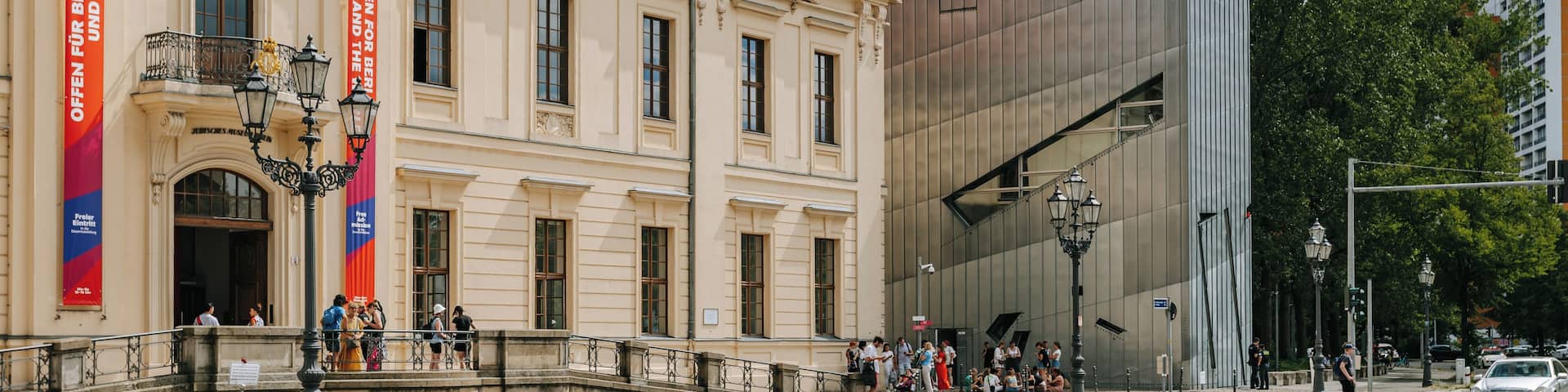 A historic building with ornate architecture and a modern glass building adjacent to it.