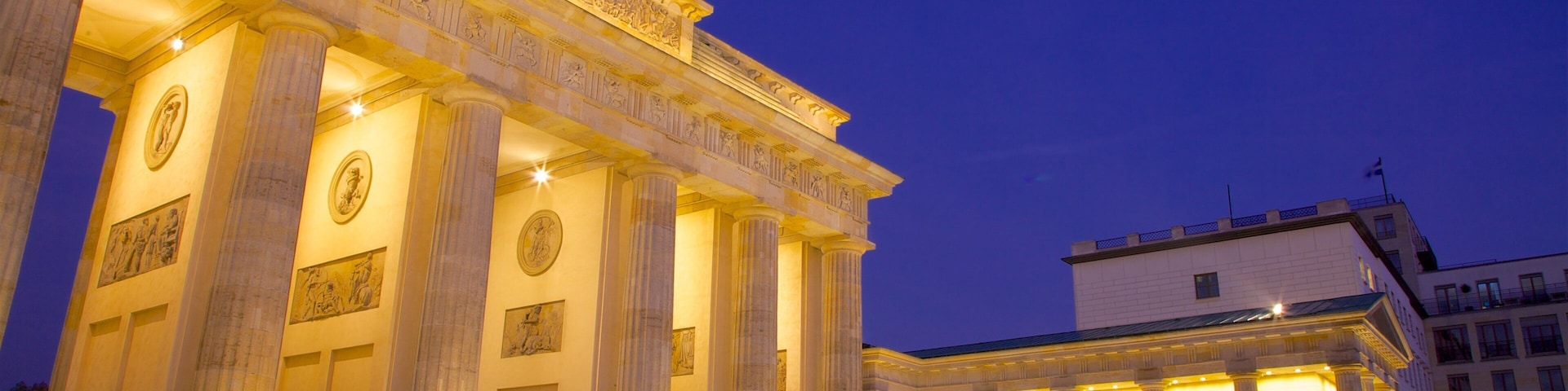 Brandenburg Gate illuminated at dusk in Berlin, showcasing neoclassical architecture and historical significance