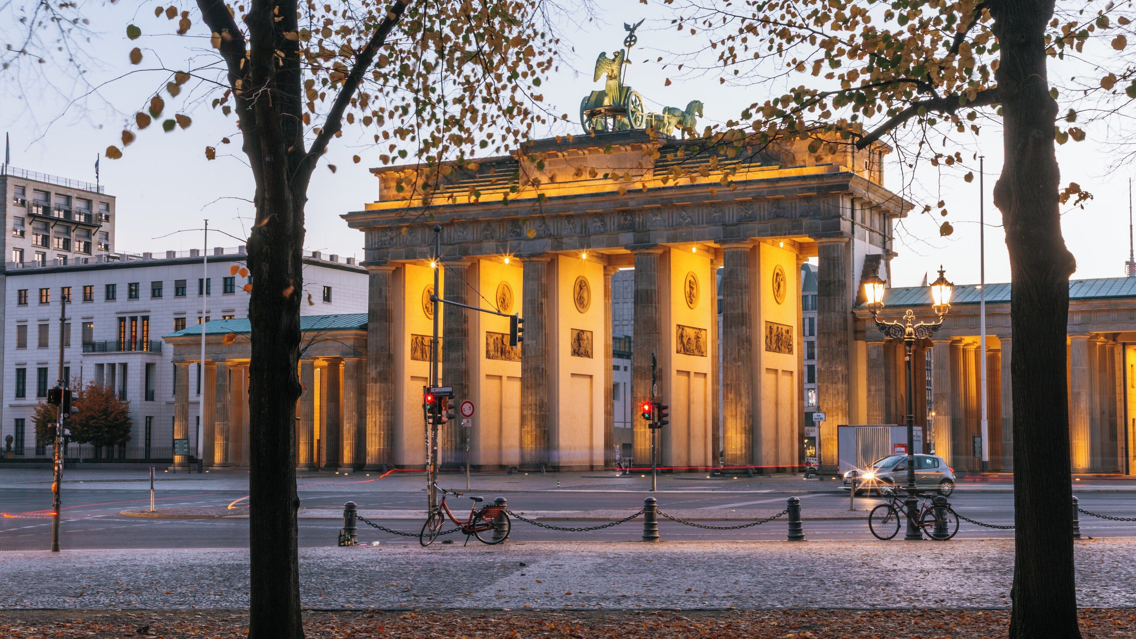 Brandenburg Gate stands illuminated at dusk, showcasing its historical architecture in Berlin’s Unter den Linden area