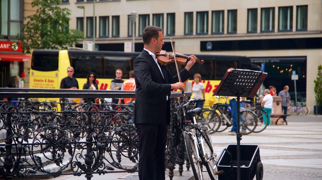 Gendarmenmarkt featuring music and street performance as well as an individual male