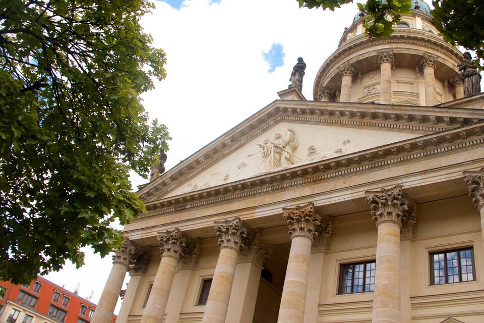 A classical building with columns, a dome, and a statue.