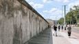 A concrete wall with a cobblestone path beside it.