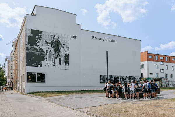 Um edifício com um grande mural em preto e branco e os dizeres "1961" e "Bernauer Straße".