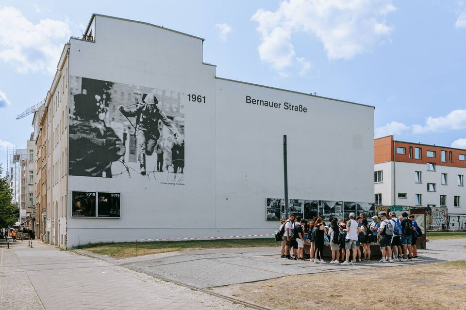 A building with a large black and white mural and the text "1961" and "Bernauer Straße".