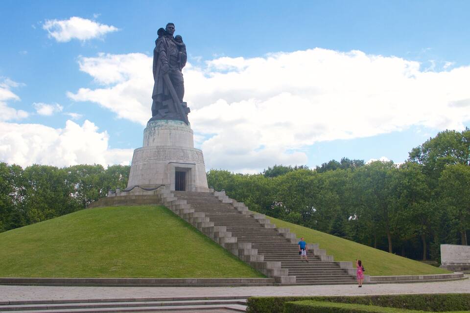 Uma grande estátua no topo de uma colina, com escadas que a levam.