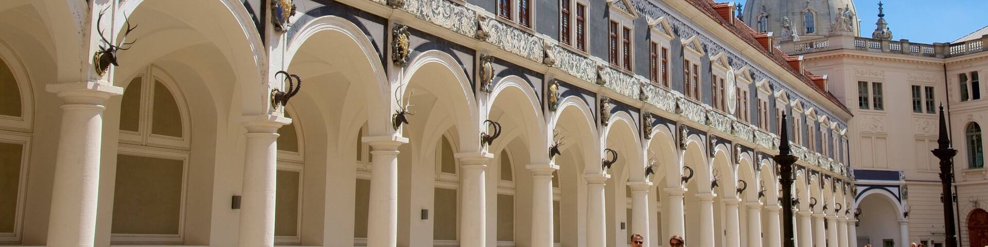 A historic building with ornate white columns and blue and white patterned facades.