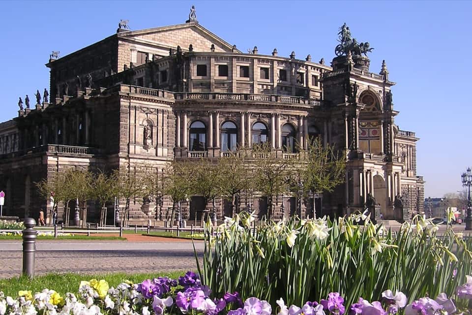 Ein historisches Gebäude mit klassischer Architektur, das Statuen und Säulen zeigt.