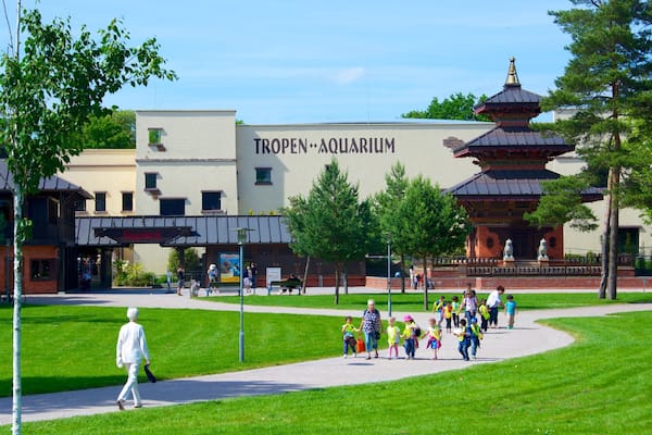 Ein Park mit einem Tropen Aquarium Gebäude, einer Pagode und Spaziergängern.