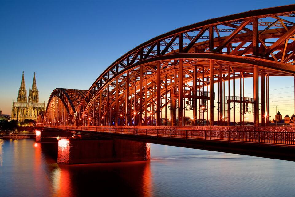 Un pont en acier avec une cathédrale en arrière-plan.