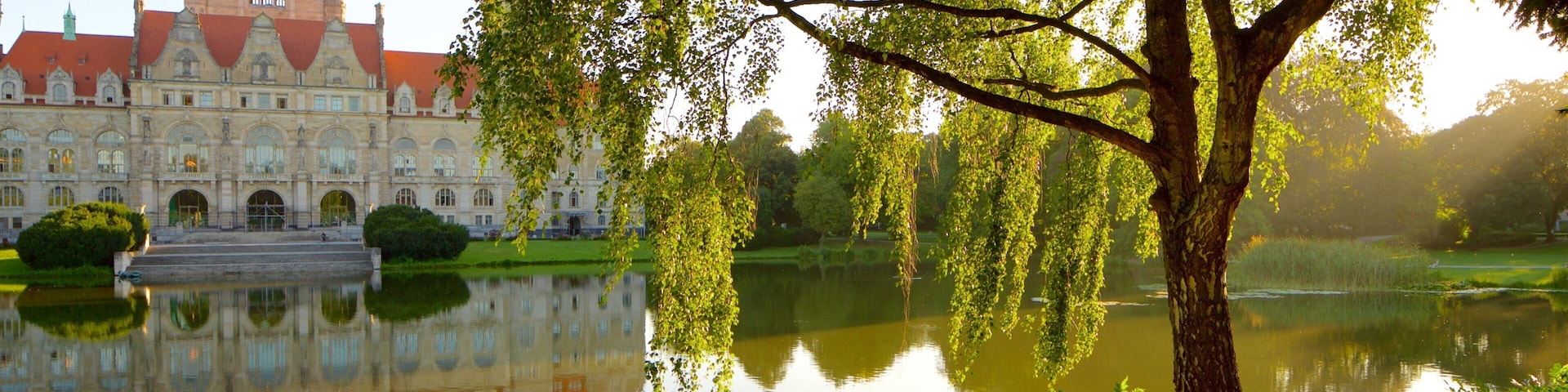 New Town Hall mostrando arquitetura de patrimônio, um pôr do sol e um lago ou charco