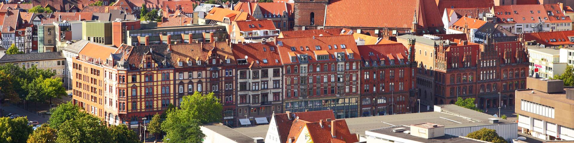 A cityscape with historic buildings, a prominent church tower, and a green dome.