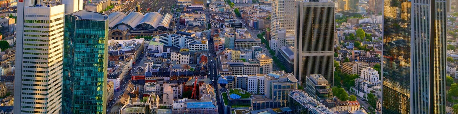 A cityscape with modern high-rise buildings, a river, and green spaces.