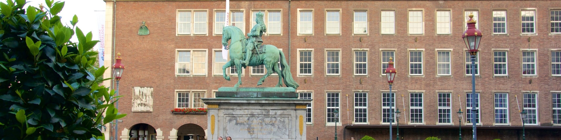 Marktplatz mostrando elementos de patrimônio e uma estátua ou escultura assim como um pequeno grupo de pessoas
