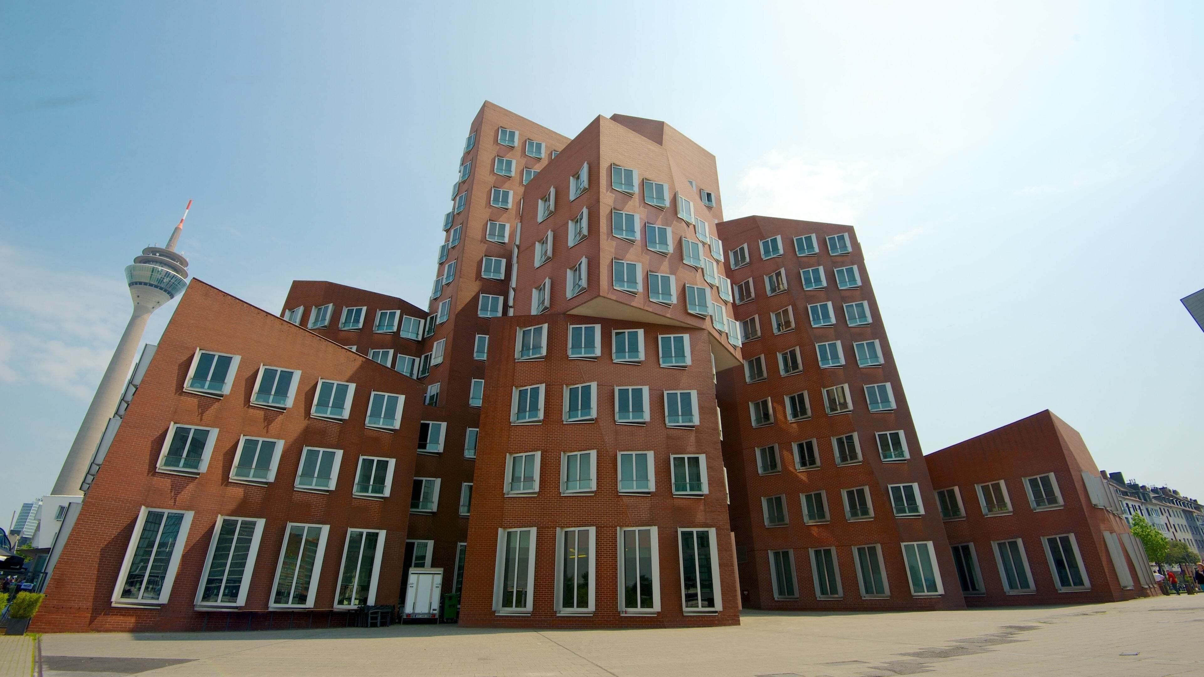 A modern architectural complex with multiple buildings featuring angular designs and numerous windows.