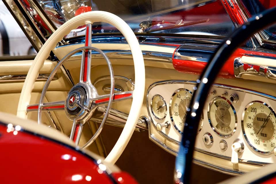 Een klassiek autoraster met een wit stuur en diverse ronde wijzerplaten.