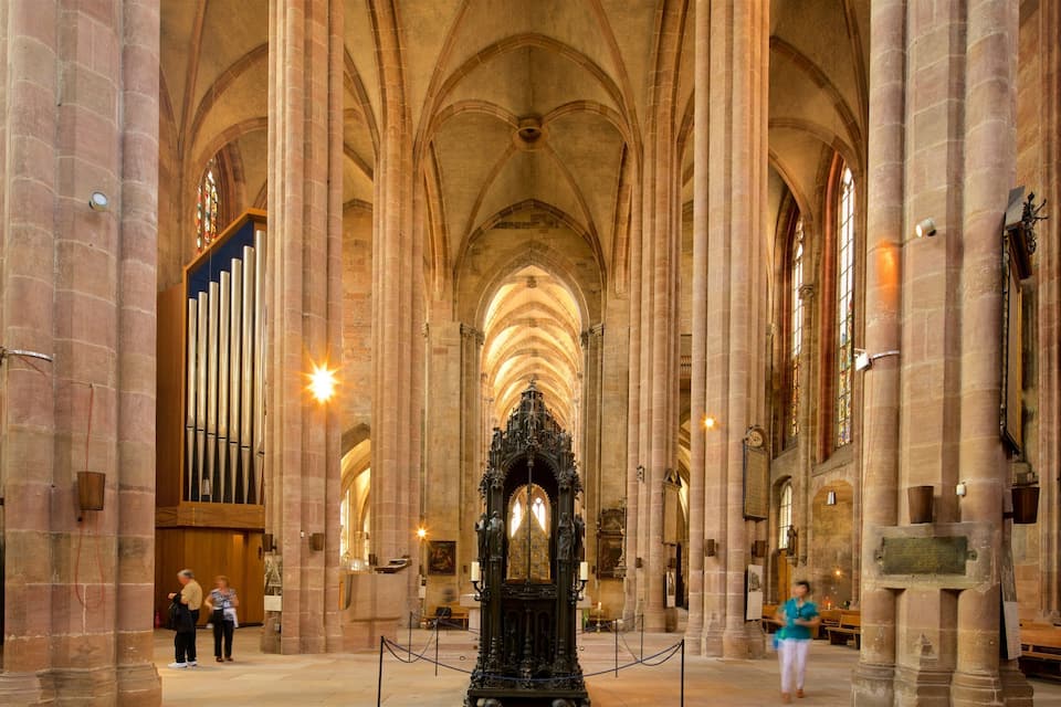 Interior d'una catedral amb alts sostres voltaics, grans columnes de pedra i un altar central ornamentat.