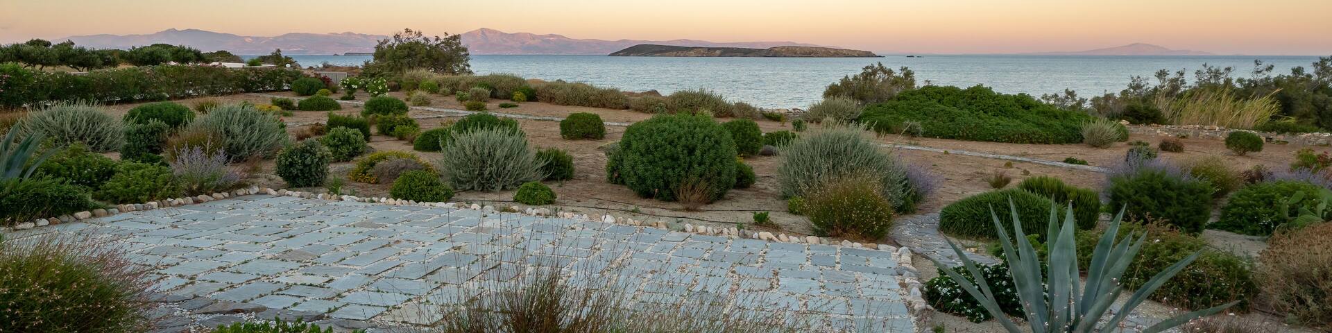Panoramic view on Naxos island from Paros Island at sunset. Typical mediterranean vegetation. soft pastel colors.