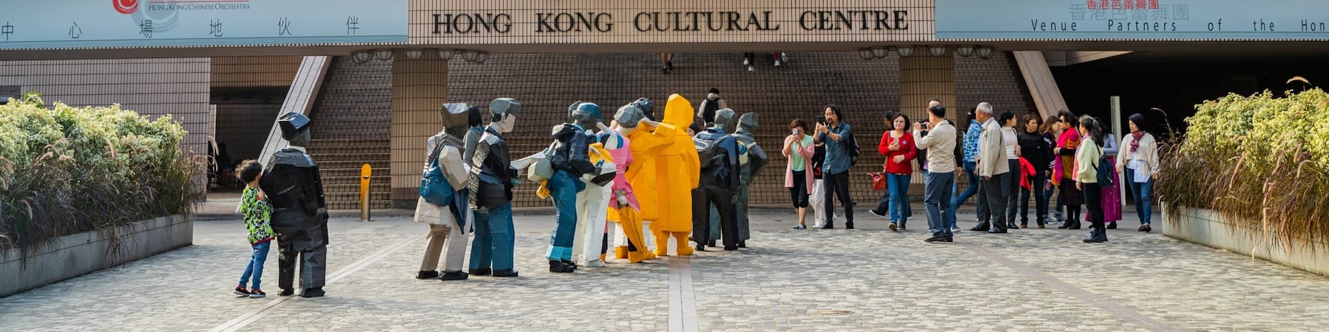 The Hong Kong Cultural Centre with a modern architectural design, featuring a prominent entrance and a signboard displaying its name.