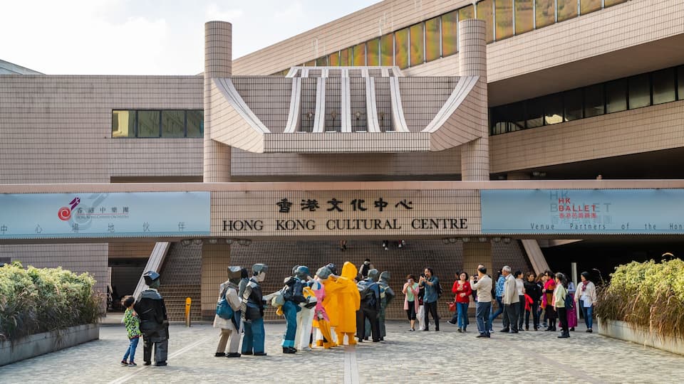 Centro Cultural de Hong Kong com design arquitetônico moderno, apresentando uma entrada imponente e uma placa com seu nome.