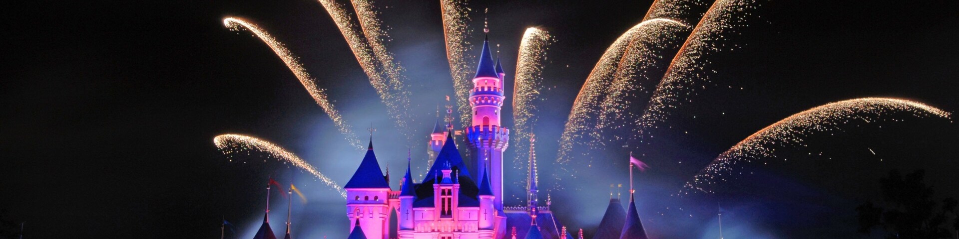 Disneylândia de Hong Kong caracterizando um pequeno castelo ou palácio, passeios e cenas noturnas
