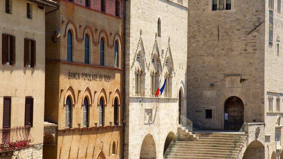 A historic building with arched windows and a staircase leading to a door.