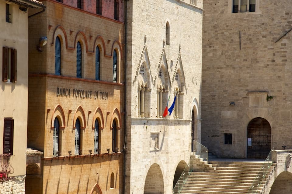 A historic building with arched windows and a staircase leading to a door.