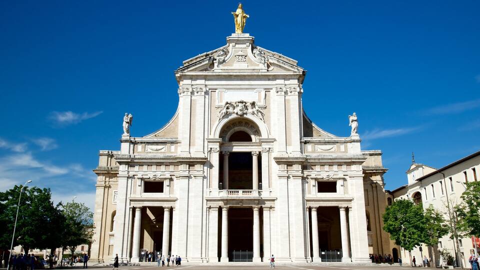 A grand neoclassical building with large columns, a central archway, and statues on the roof.