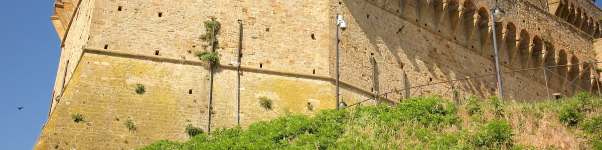 A historic stone fortress with arched windows and a watchtower.