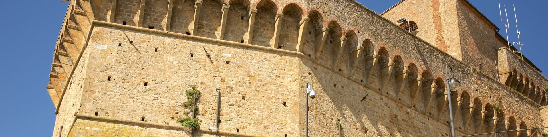 Una fortaleza histórica de piedra con ventanas de arco y una torre de vigilancia.