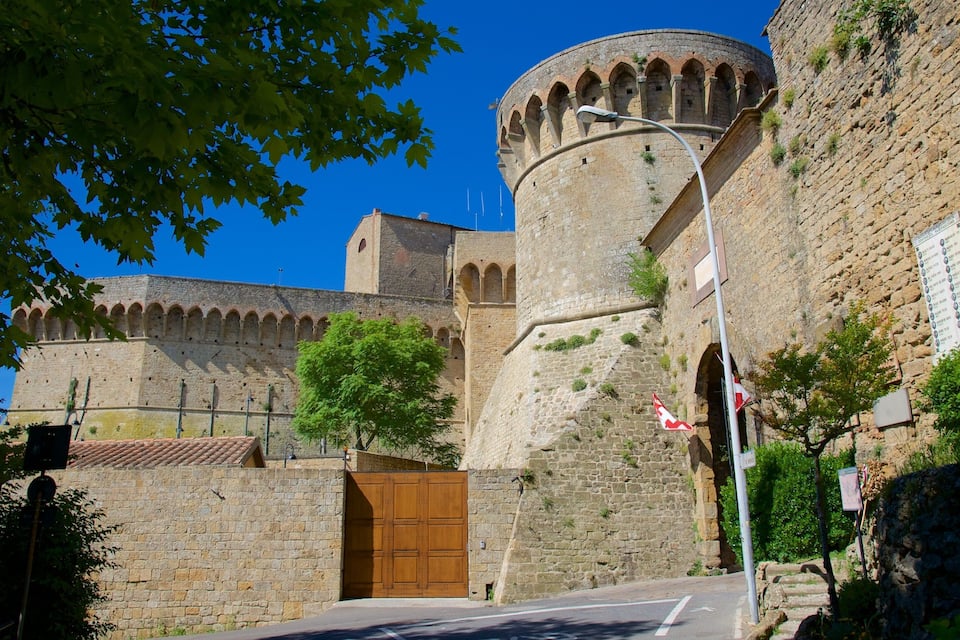 A historic stone fortress with a large wooden gate and a round tower.