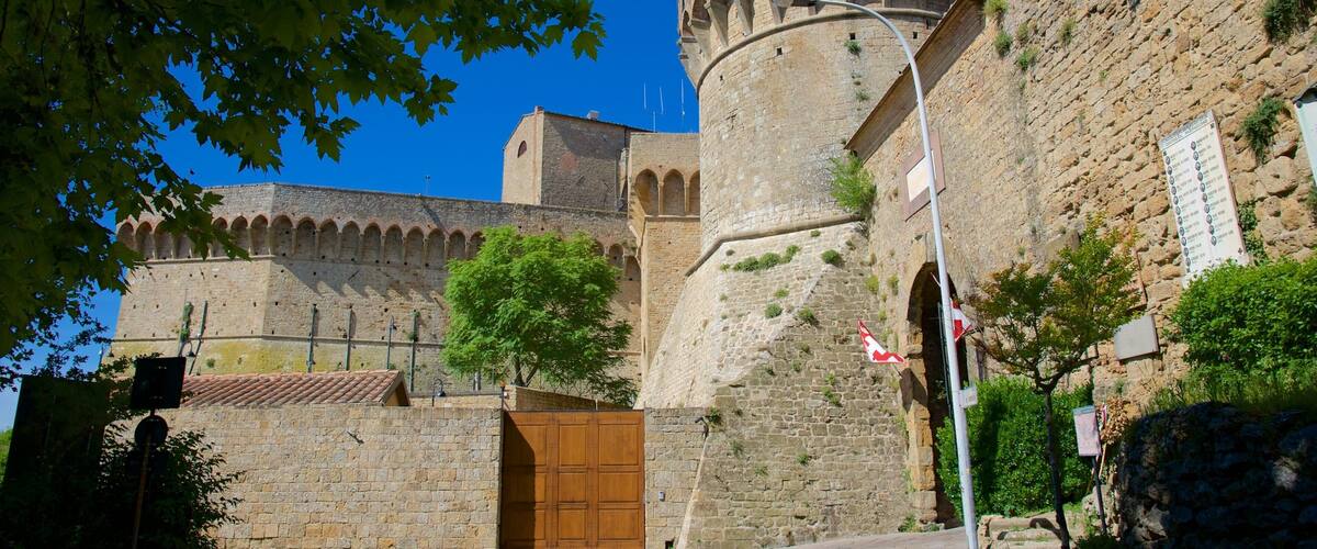 A historic stone fortress with a large wooden gate and a round tower.