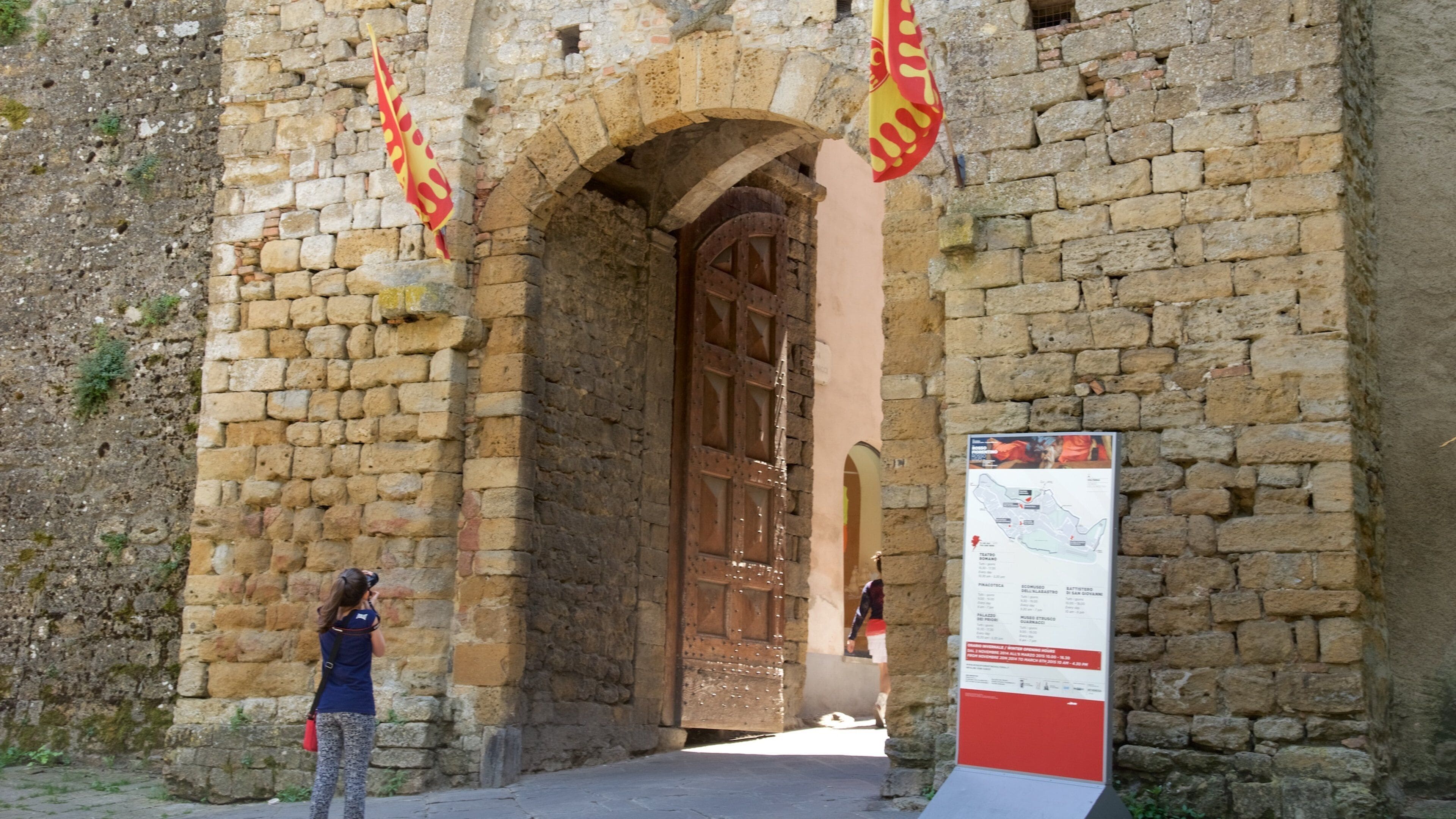 Porta all\'Arco som viser skiltning og historiske bygningsværker såvel som en kvinde