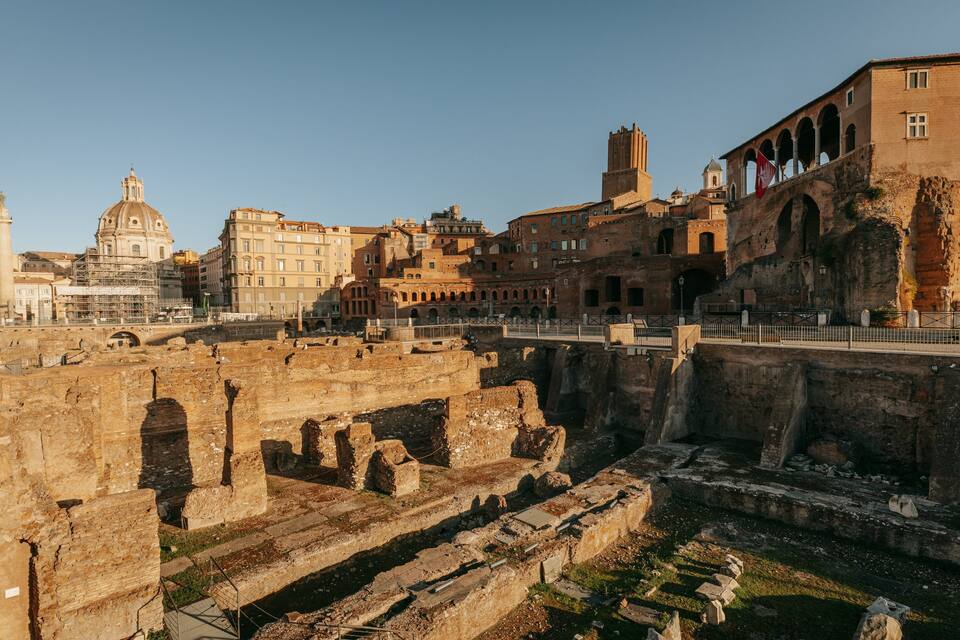 Ruínas antigas com uma ponte, edifícios históricos e uma estrutura em cúpula imponente.